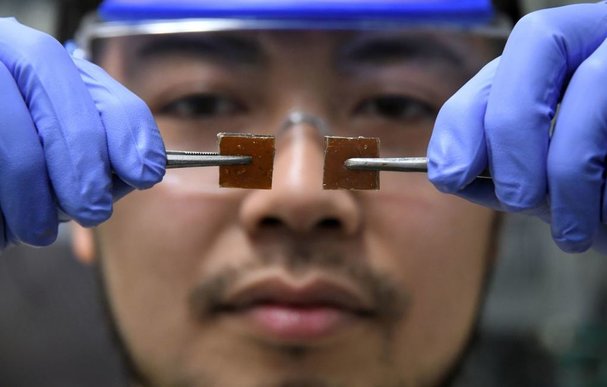 Yu Yanagisawa, a chemistry researcher at the University of Tokyo, displays two broken pieces of resin glass before repairing them at the university's lab.<br/>